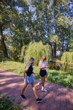 İki orta yaşlı kız kardeş bir yaz sabahını parkta dinlenerek ve eğlenerek geçiriyorlar..