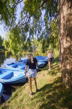 İki orta yaşlı kız kardeş bir yaz sabahını parkta dinlenerek ve eğlenerek geçiriyorlar..