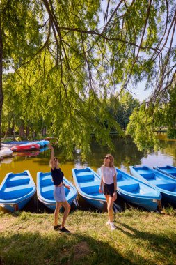 İki orta yaşlı kız kardeş bir yaz sabahını parkta dinlenerek ve eğlenerek geçiriyorlar..