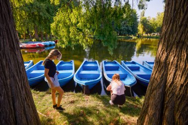 İki orta yaşlı kız kardeş bir yaz sabahını parkta dinlenerek ve eğlenerek geçiriyorlar..