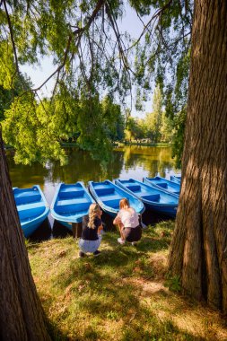 İki orta yaşlı kız kardeş bir yaz sabahını parkta dinlenerek ve eğlenerek geçiriyorlar..