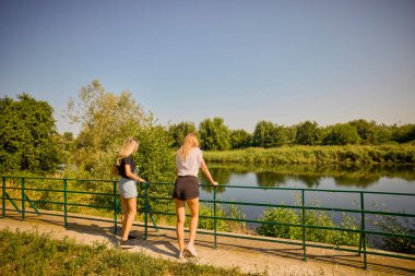 İki orta yaşlı kız kardeş bir yaz sabahını parkta dinlenerek ve eğlenerek geçiriyorlar..