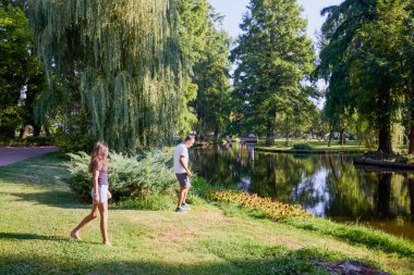 Baba ve kızı bir yaz sabahı göl kenarında parkta birlikte vakit geçiriyorlar doğanın tadını çıkarıyorlar..