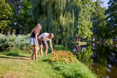 Baba ve kızı bir yaz sabahı göl kenarında parkta birlikte vakit geçiriyorlar doğanın tadını çıkarıyorlar..
