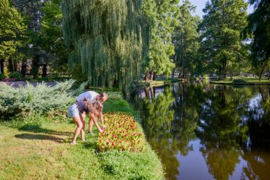 Baba ve kızı bir yaz sabahı göl kenarında parkta birlikte vakit geçiriyorlar doğanın tadını çıkarıyorlar..