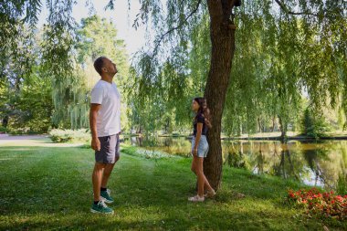 Baba ve kızı bir yaz sabahı göl kenarında parkta birlikte vakit geçiriyorlar doğanın tadını çıkarıyorlar..