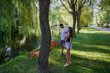 Baba ve kızı bir yaz sabahı göl kenarında parkta birlikte vakit geçiriyorlar doğanın tadını çıkarıyorlar..