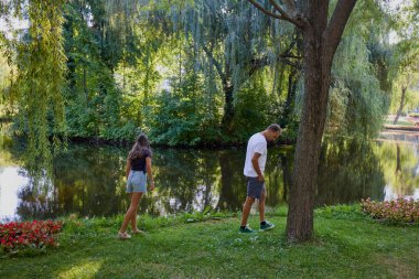 Baba ve kızı bir yaz sabahı göl kenarında parkta birlikte vakit geçiriyorlar doğanın tadını çıkarıyorlar..