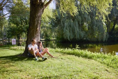 Baba ve kızı bir yaz sabahı göl kenarında parkta birlikte vakit geçiriyorlar doğanın tadını çıkarıyorlar..