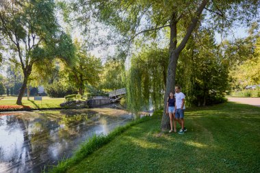 Baba ve kızı bir yaz sabahı göl kenarında parkta birlikte vakit geçiriyorlar doğanın tadını çıkarıyorlar..