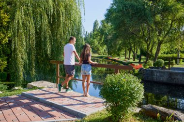 Baba ve kızı bir yaz sabahı göl kenarında parkta birlikte vakit geçiriyorlar doğanın tadını çıkarıyorlar..