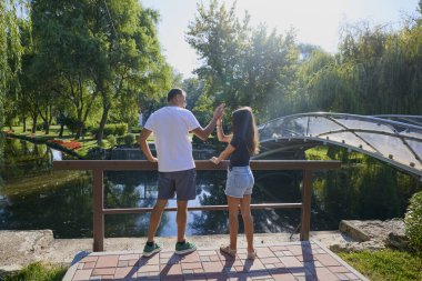 Baba ve kızı bir yaz sabahı göl kenarında parkta birlikte vakit geçiriyorlar doğanın tadını çıkarıyorlar..