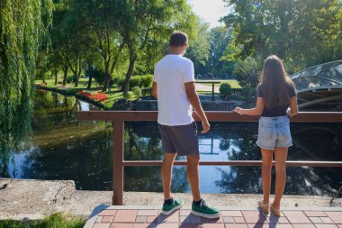 Baba ve kızı bir yaz sabahı göl kenarında parkta birlikte vakit geçiriyorlar doğanın tadını çıkarıyorlar..