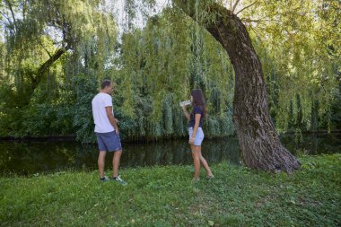 Baba ve kızı bir yaz sabahı göl kenarında parkta birlikte vakit geçiriyorlar doğanın tadını çıkarıyorlar..