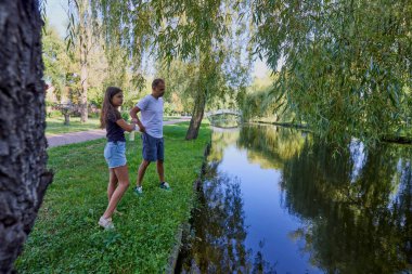 Baba ve kızı bir yaz sabahı göl kenarında parkta birlikte vakit geçiriyorlar doğanın tadını çıkarıyorlar..
