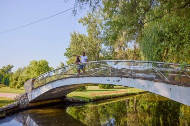 Baba ve kızı bir yaz sabahı göl kenarında parkta birlikte vakit geçiriyorlar doğanın tadını çıkarıyorlar..