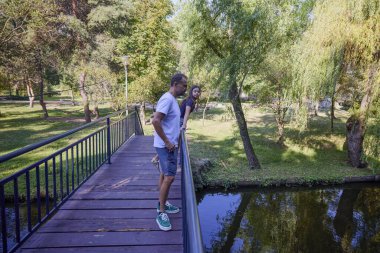 Baba ve kızı bir yaz sabahı göl kenarında parkta birlikte vakit geçiriyorlar doğanın tadını çıkarıyorlar..