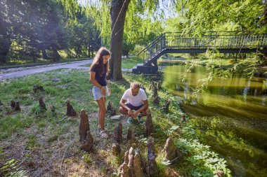 Baba ve kızı bir yaz sabahı göl kenarında parkta birlikte vakit geçiriyorlar doğanın tadını çıkarıyorlar..