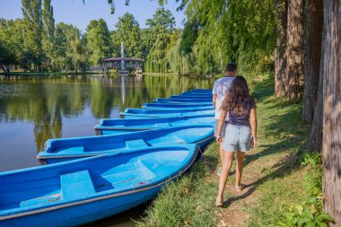 Baba ve kızı bir yaz sabahı göl kenarında parkta birlikte vakit geçiriyorlar doğanın tadını çıkarıyorlar..