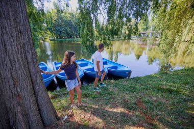 Baba ve kızı bir yaz sabahı göl kenarında parkta birlikte vakit geçiriyorlar doğanın tadını çıkarıyorlar..