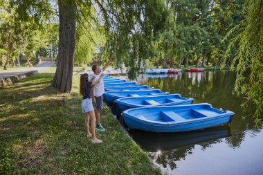 Baba ve kızı bir yaz sabahı göl kenarında parkta birlikte vakit geçiriyorlar doğanın tadını çıkarıyorlar..