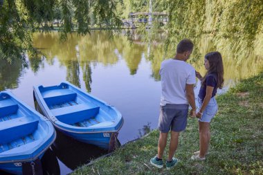 Baba ve kızı bir yaz sabahı göl kenarında parkta birlikte vakit geçiriyorlar doğanın tadını çıkarıyorlar..