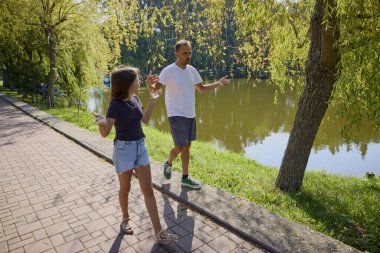 Baba ve kızı bir yaz sabahı göl kenarında parkta birlikte vakit geçiriyorlar doğanın tadını çıkarıyorlar..