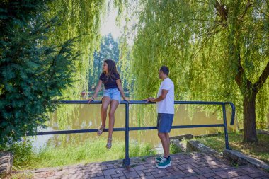 Baba ve kızı bir yaz sabahı göl kenarında parkta birlikte vakit geçiriyorlar doğanın tadını çıkarıyorlar..