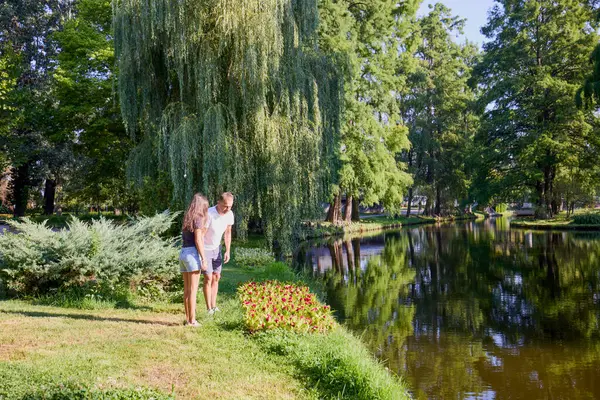 Baba ve kızı bir yaz sabahı göl kenarında parkta birlikte vakit geçiriyorlar doğanın tadını çıkarıyorlar..