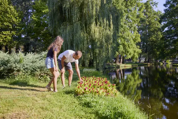Baba ve kızı bir yaz sabahı göl kenarında parkta birlikte vakit geçiriyorlar doğanın tadını çıkarıyorlar..