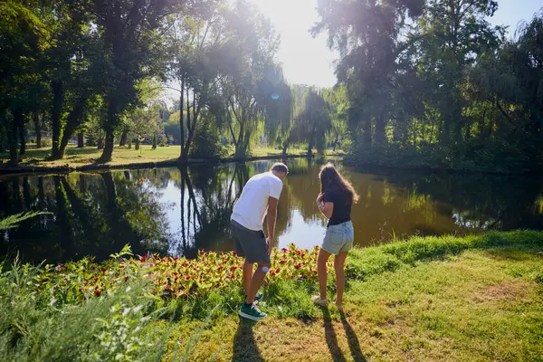 Baba ve kızı bir yaz sabahı göl kenarında parkta birlikte vakit geçiriyorlar doğanın tadını çıkarıyorlar..