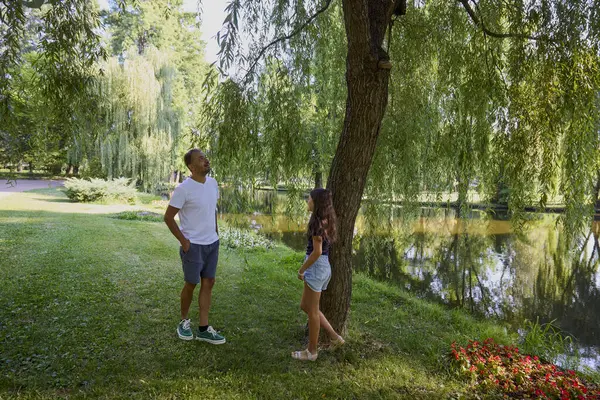 Baba ve kızı bir yaz sabahı göl kenarında parkta birlikte vakit geçiriyorlar doğanın tadını çıkarıyorlar..