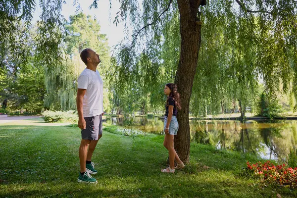 Baba ve kızı bir yaz sabahı göl kenarında parkta birlikte vakit geçiriyorlar doğanın tadını çıkarıyorlar..