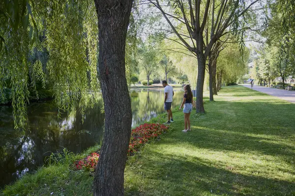Baba ve kızı bir yaz sabahı göl kenarında parkta birlikte vakit geçiriyorlar doğanın tadını çıkarıyorlar..