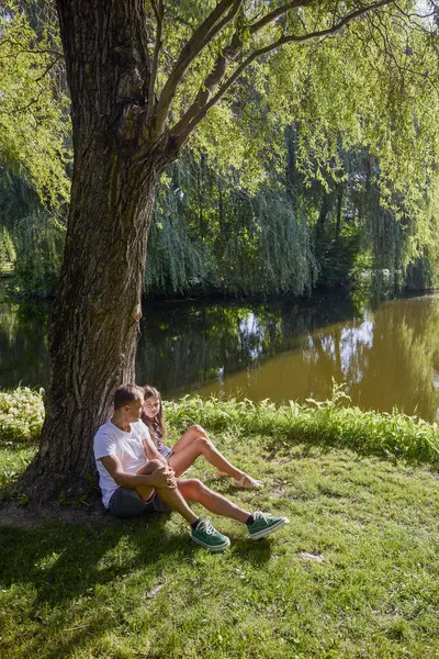 Baba ve kızı bir yaz sabahı göl kenarında parkta birlikte vakit geçiriyorlar doğanın tadını çıkarıyorlar..