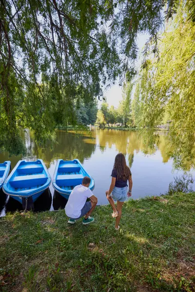 Baba ve kızı bir yaz sabahı göl kenarında parkta birlikte vakit geçiriyorlar doğanın tadını çıkarıyorlar..