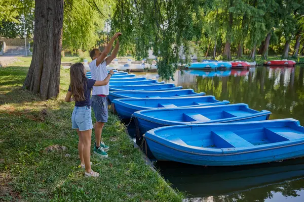Baba ve kızı bir yaz sabahı göl kenarında parkta birlikte vakit geçiriyorlar doğanın tadını çıkarıyorlar..
