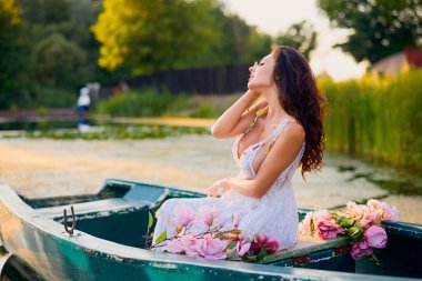 Akşamüstü gölde çiçekli beyaz elbiseli güzel bir kadın..