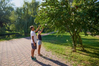 Baba ve kızı parkta birlikte zaman geçiriyorlar. Egzersiz yapıyor ve dinleniyorlar..