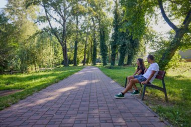 Baba ve kızı parkta birlikte zaman geçiriyorlar. Egzersiz yapıyor ve dinleniyorlar..