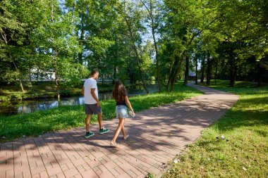 Baba ve kızı parkta birlikte zaman geçiriyorlar. Egzersiz yapıyor ve dinleniyorlar..