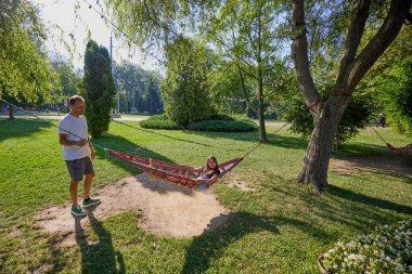 Baba ve kızı parkta birlikte zaman geçiriyorlar. Egzersiz yapıyor ve dinleniyorlar..