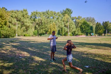 Baba ve kızı parkta birlikte zaman geçiriyorlar. Egzersiz yapıyor ve dinleniyorlar..