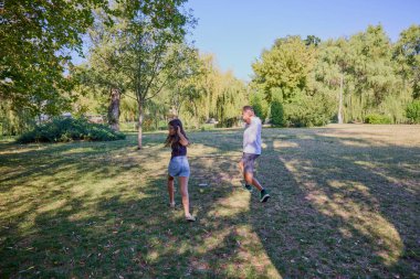 Baba ve kızı parkta birlikte zaman geçiriyorlar. Egzersiz yapıyor ve dinleniyorlar..