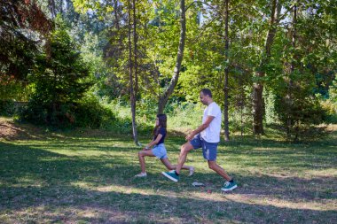 Baba ve kızı parkta birlikte zaman geçiriyorlar. Egzersiz yapıyor ve dinleniyorlar..