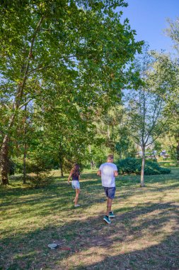 Baba ve kızı parkta birlikte zaman geçiriyorlar. Egzersiz yapıyor ve dinleniyorlar..