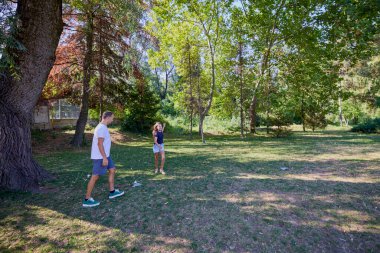 Baba ve kızı parkta birlikte zaman geçiriyorlar. Egzersiz yapıyor ve dinleniyorlar..