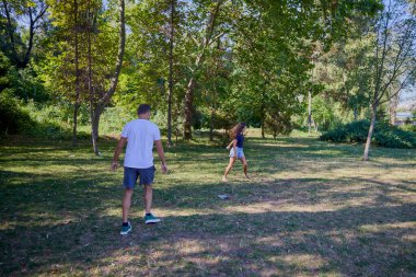 Baba ve kızı parkta birlikte zaman geçiriyorlar. Egzersiz yapıyor ve dinleniyorlar..