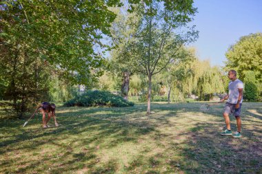 Baba ve kızı parkta birlikte zaman geçiriyorlar. Egzersiz yapıyor ve dinleniyorlar..