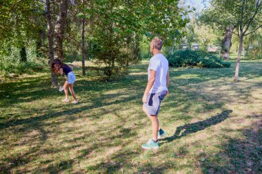 Baba ve kızı parkta birlikte zaman geçiriyorlar. Egzersiz yapıyor ve dinleniyorlar..